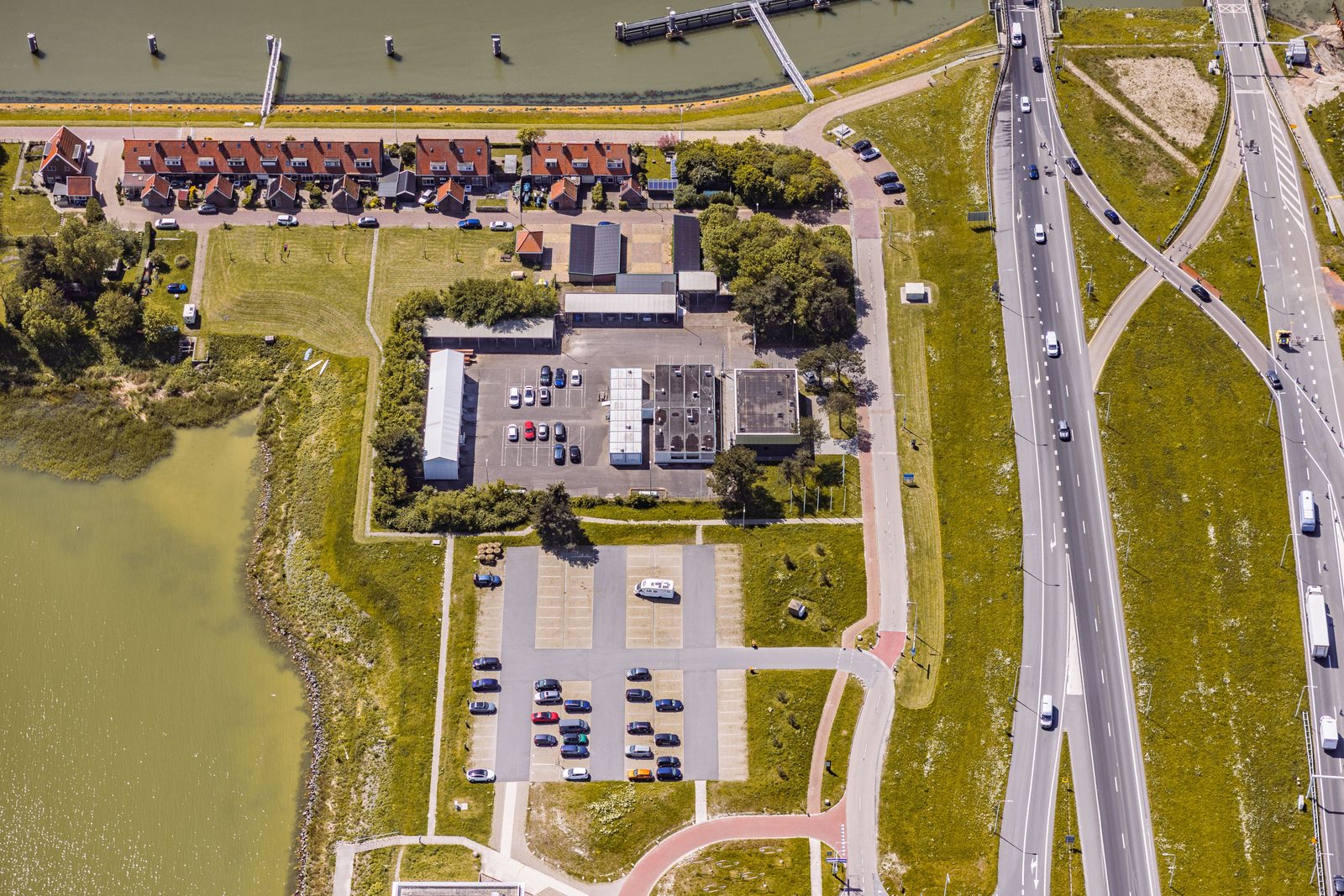 Luchtfoto van gebouwen en wegen bij de Afsluitdijk