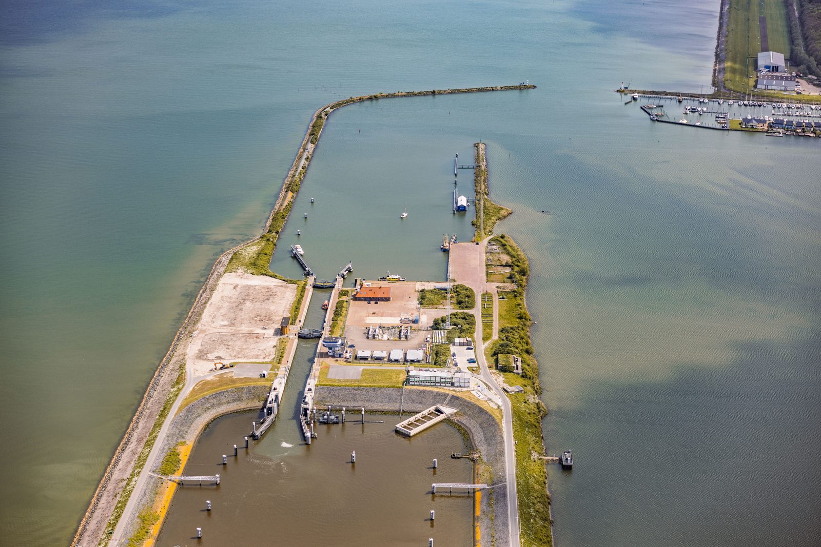 Luchtfoto van een havendam met gemaal bij de Afsluitdijk