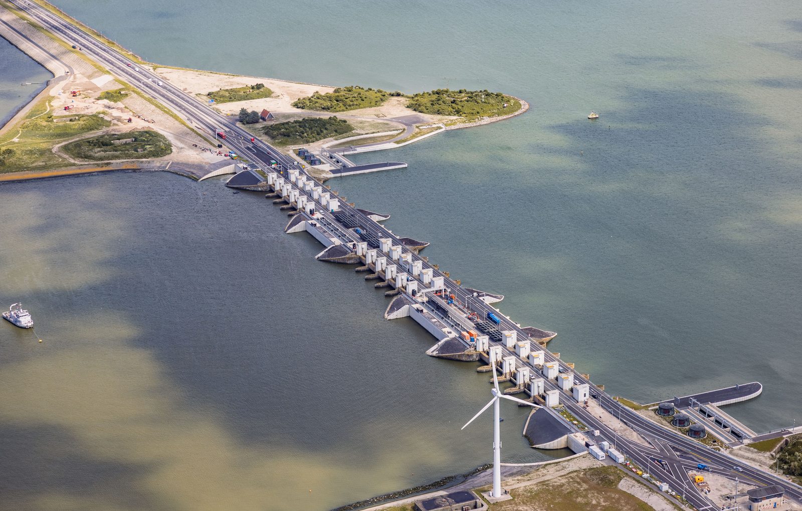 Afsluitdijk spuicomplex met windturbine, luchtfoto